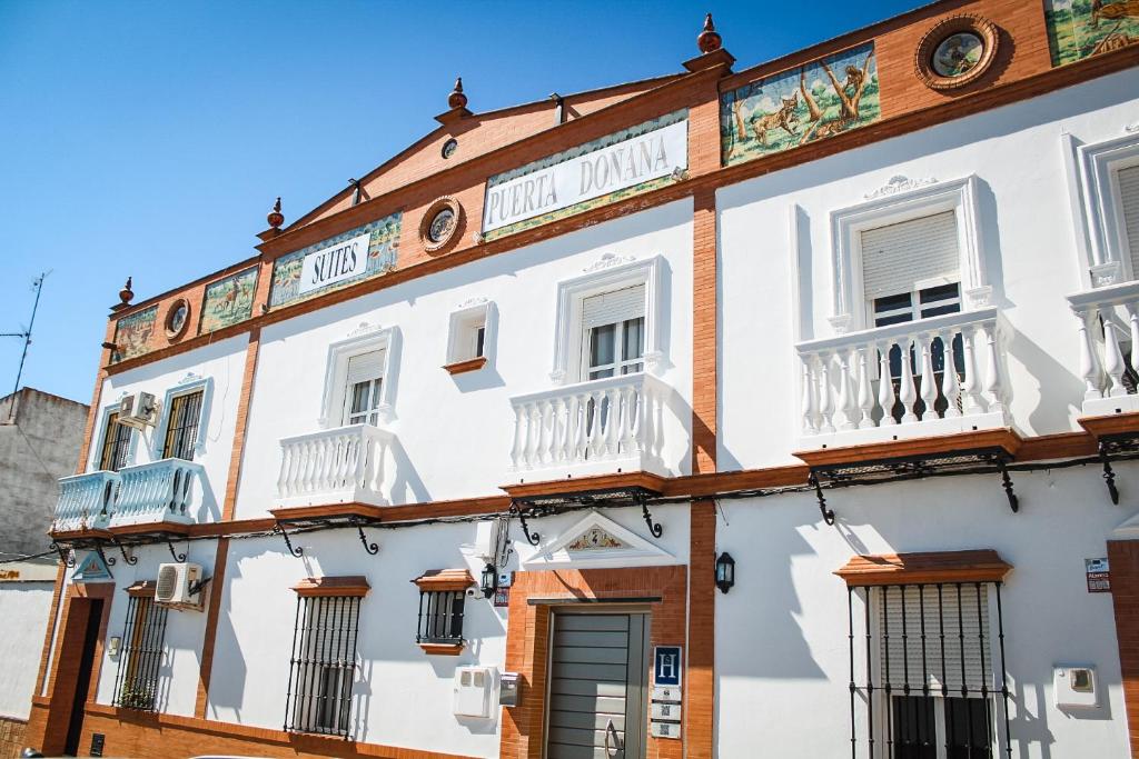 a white building with windows and balconies at Suites Puerta Doñana in Hinojos