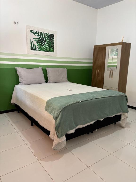 a large bed in a room with a green wall at Casa Viturino in Tailandia