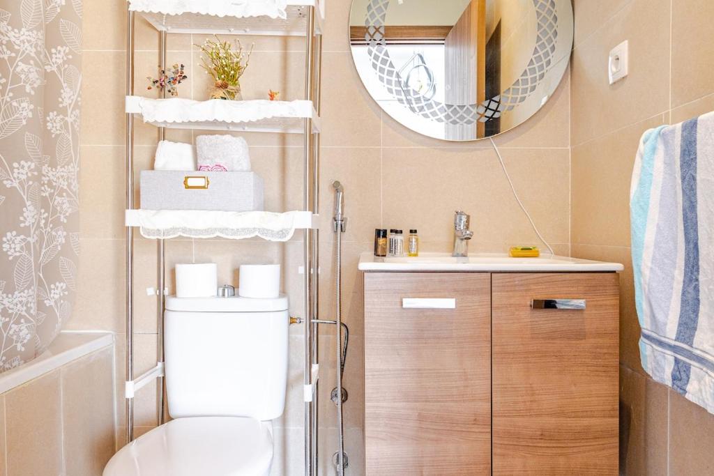 a bathroom with a toilet and a sink and a mirror at Appartement en bord de mer idéal pour les vacances in Imi Ouaddar