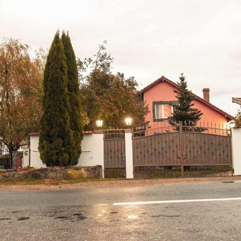 a house with a wooden fence and a tree at Casa Adriana in Ileni