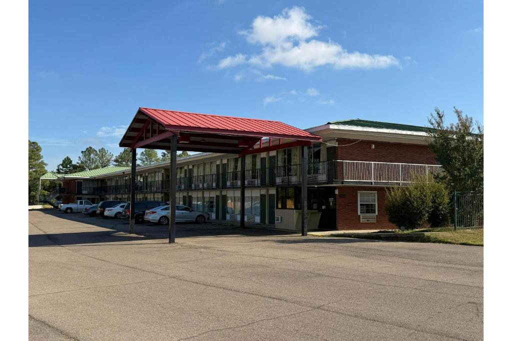 a building with a red roof on a street at Hotel O Star Motel Hattiesburg HWY 49 in Hattiesburg