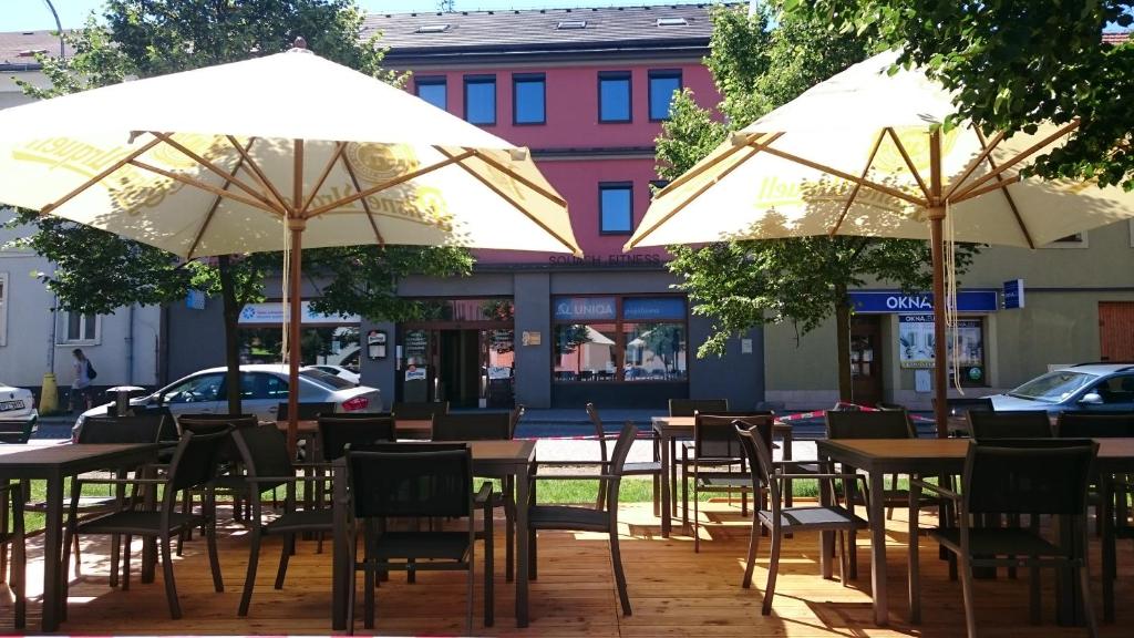 dwa stoły i krzesła z parasolami na ulicy w obiekcie Hotel Kaskada w mieście Ledeč nad Sázavou