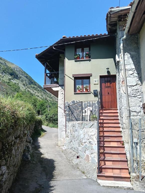 a house with a staircase leading to a door at La Casuca de Remin in Arredondo