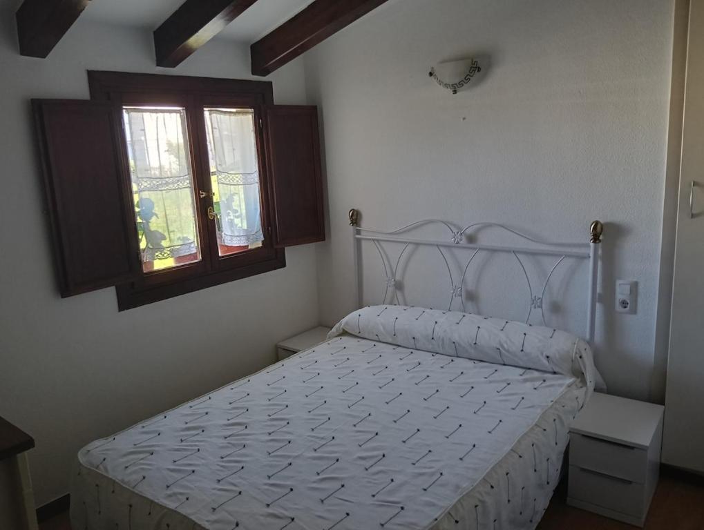 a white bed in a bedroom with a window at La Casuca de Remin in Arredondo