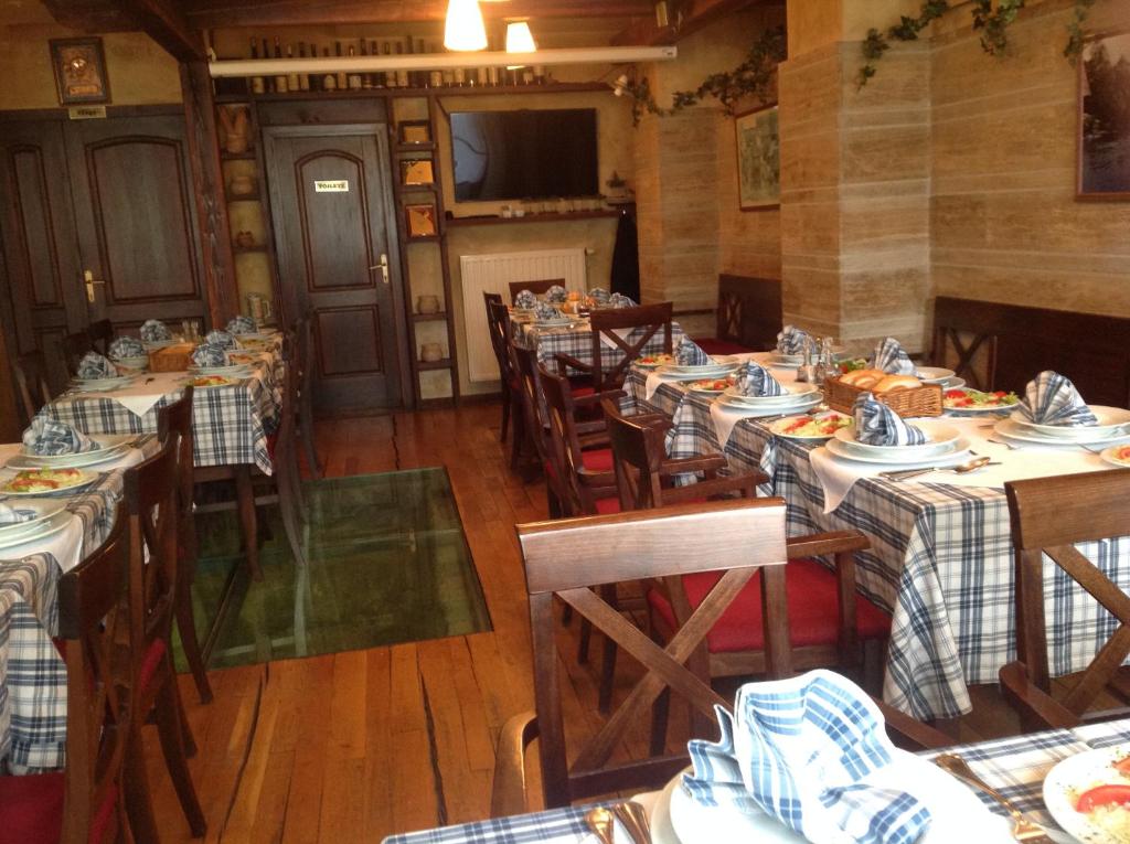 un restaurante con mesas y sillas con comida. en Hotel Stari grad, en Jajce