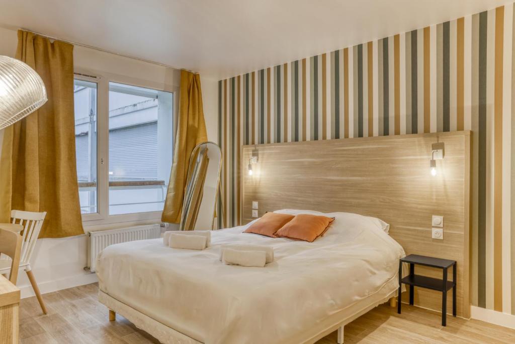 a bedroom with a large white bed with orange pillows at Colivi Studio Cosy 50m Gare Annemasse in Annemasse