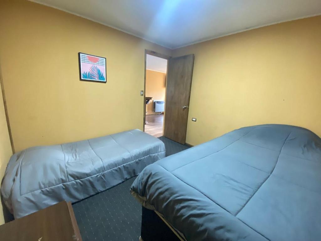 a hotel room with two beds and a window at Apartamentos Natales May 21 in Puerto Natales