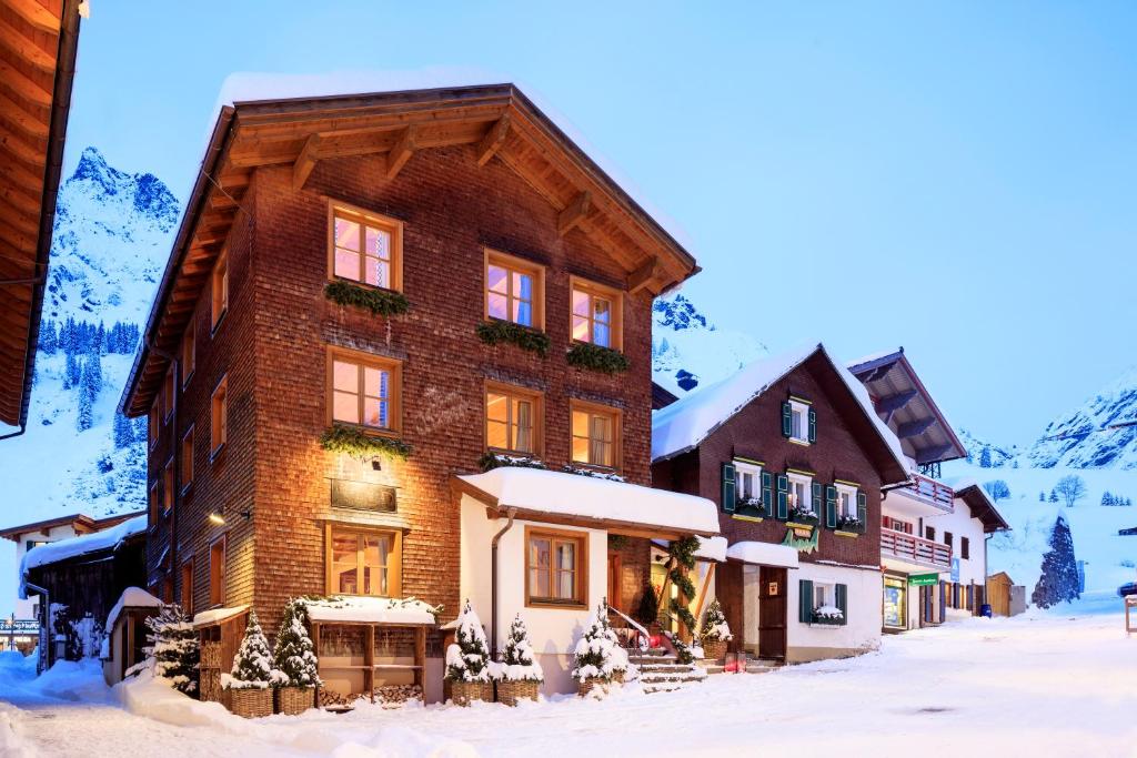 un gran edificio de madera en la nieve en House Hannes Schneider Stuben, en Stuben am Arlberg
