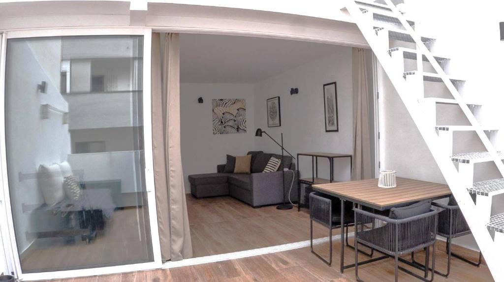 sala de estar con escalera, mesa y sofá en Sita Urban Home, en Las Palmas de Gran Canaria