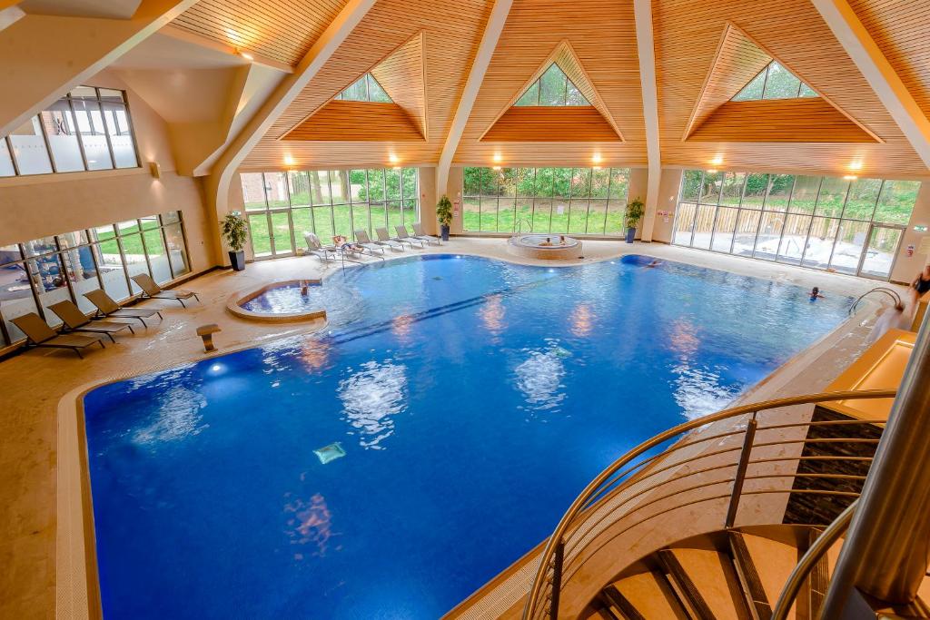a large swimming pool in a large room with windows at Landal Kenwick Woods in Louth