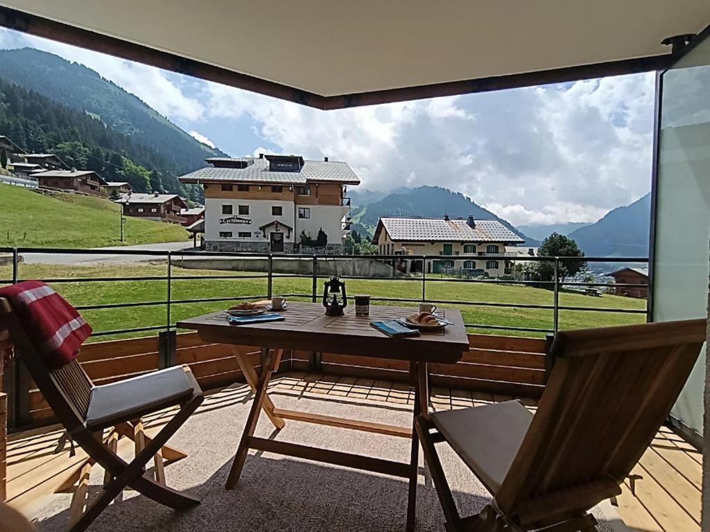 une table et des chaises sur un balcon avec vue dans l'établissement NEW APT, 100m from ski lift, à Châtel