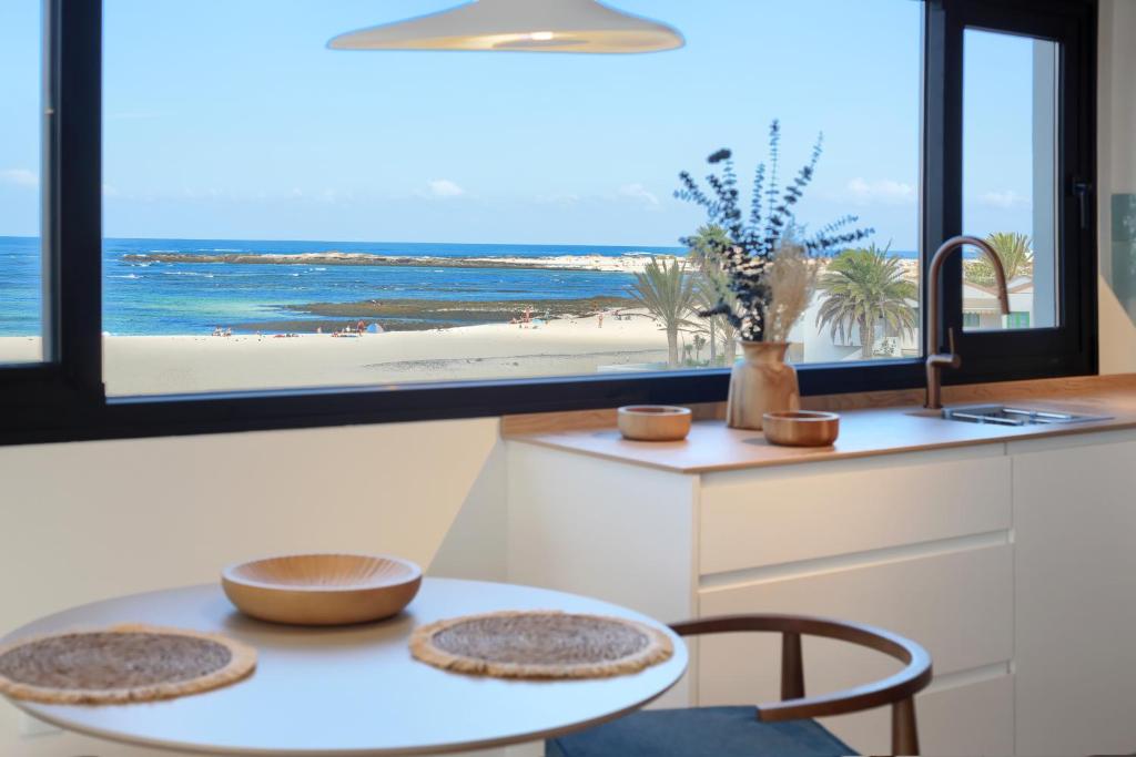 a kitchen with a table and a view of the beach at Silvic Aguaviva in Cotillo