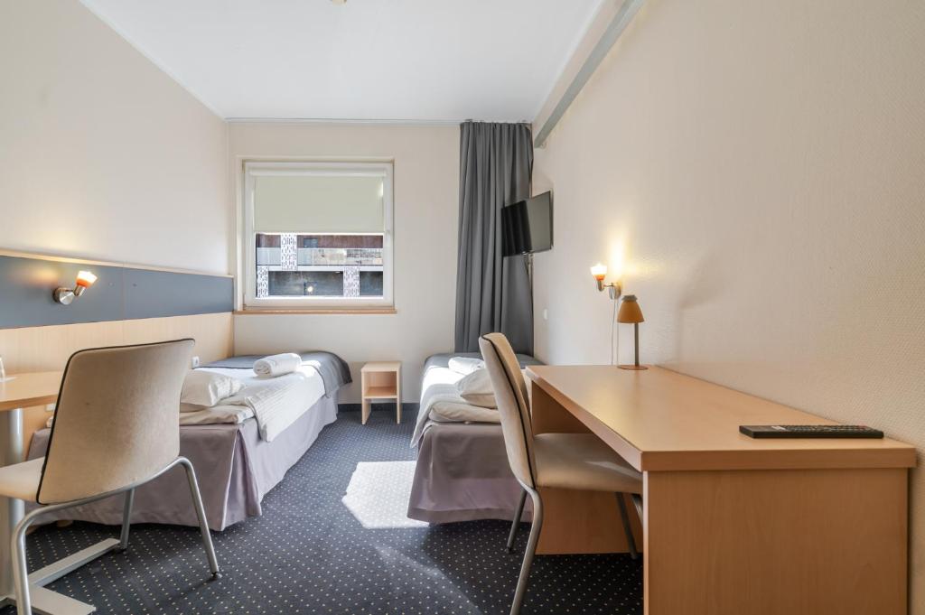 a hotel room with two beds and a desk at Aparthotel Skylight Katowice by BookingHost in Katowice