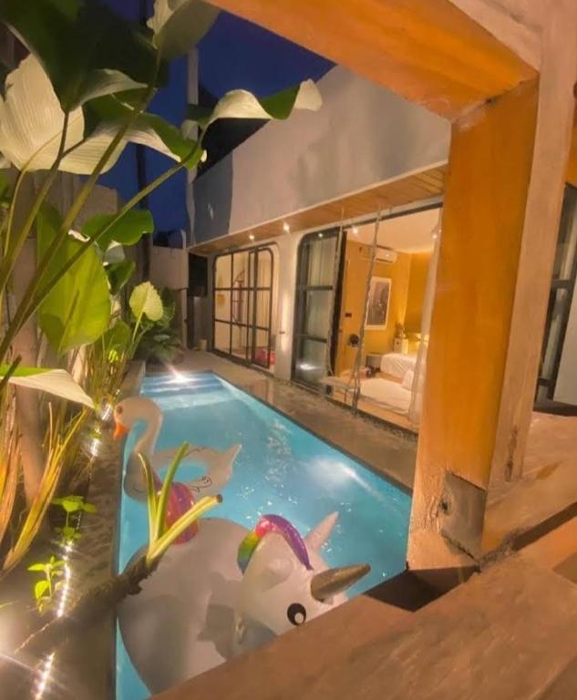 a swimming pool with an aquarium in a house at Akaya Villas Solo in Kemiri