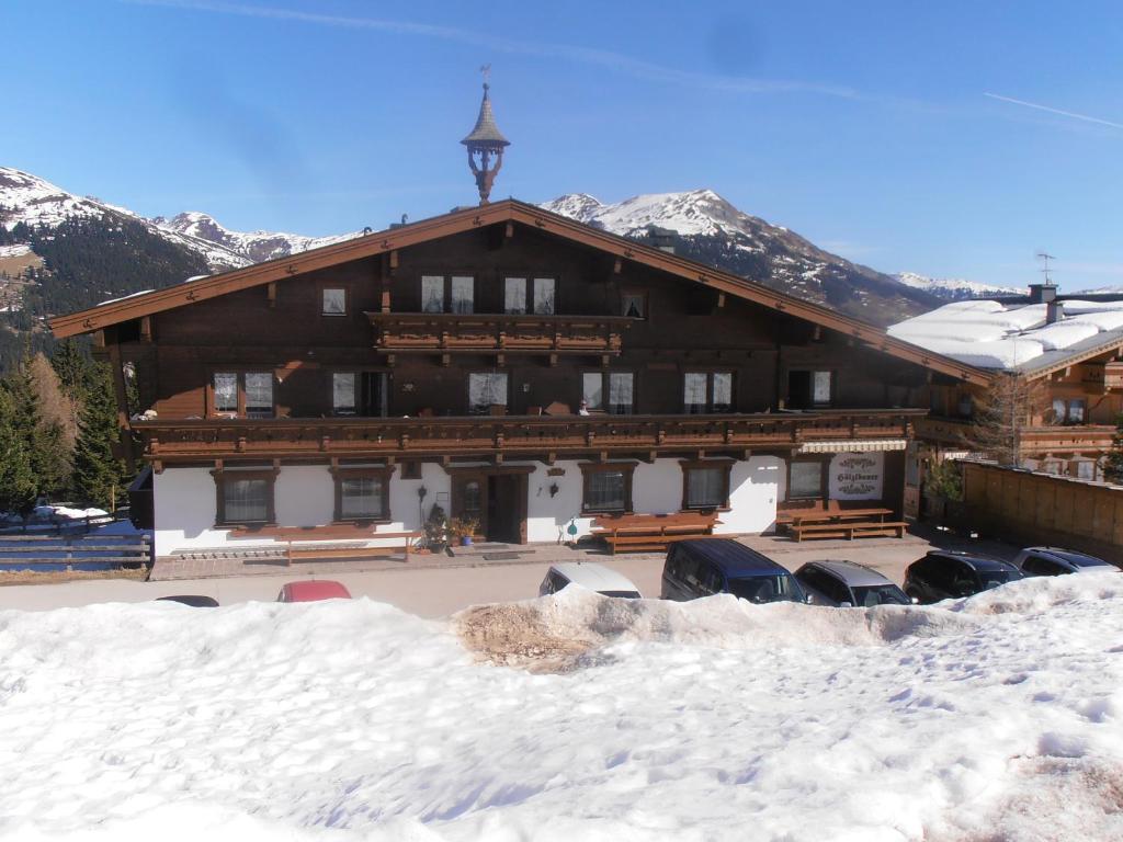 a large building with cars parked in the snow at Gästehaus Hölzlbauer in Krimml