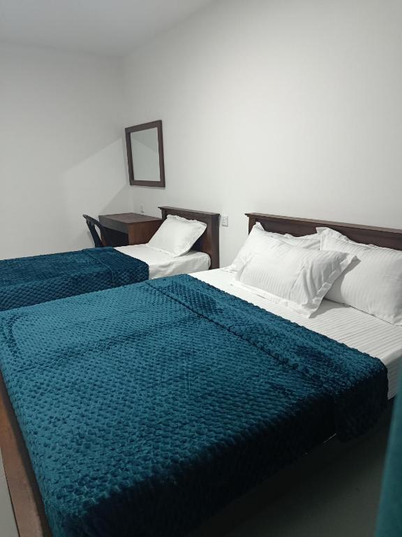 two beds sitting next to each other in a room at Magnola Hotels in Bandarawela