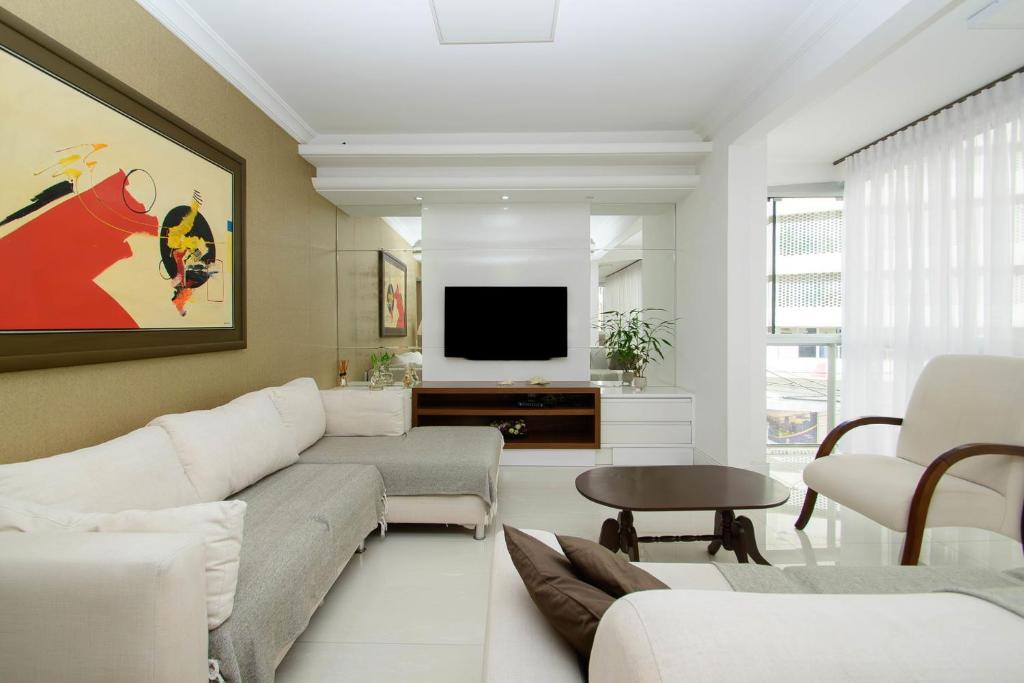 un salon avec un canapé et une télévision dans l'établissement Apto c/ 2 vagas no centro perto da praia QP5165, à Balneário Camboriú