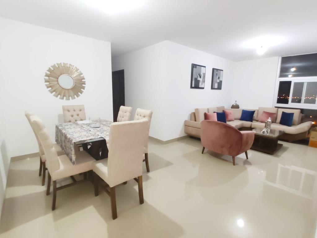 una sala da pranzo con tavolo, sedie e divano di Exclusive, Elegant Atlantis Comfortable a Santa Cruz de la Sierra