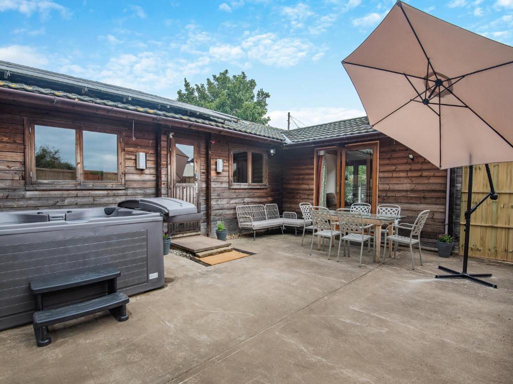 a patio with a grill and an umbrella at Mayfield Lodge - Uk39917 in Heckington