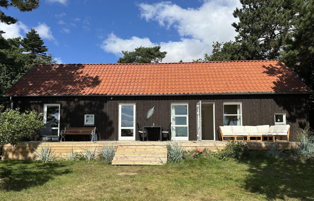 a small house with an orange roof at House direct to beach in Greve