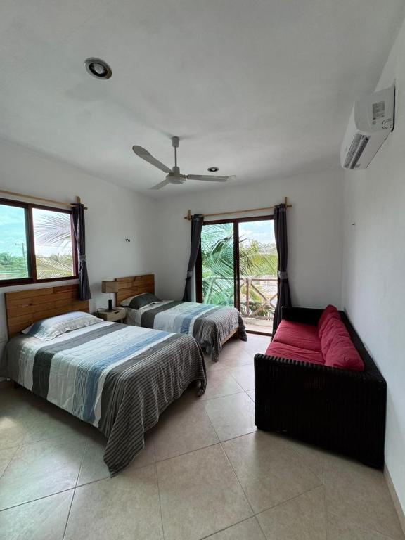 a bedroom with two beds and a couch in it at Punta Arena Condominium in Chicxulub