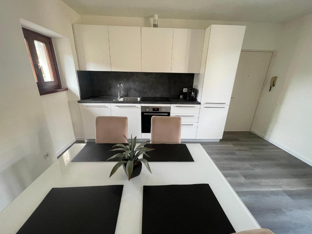 VacalloにあるVacallo Panorama Apartament - RentuGoo Travelのキッチン(テーブル、椅子2脚、シンク付)