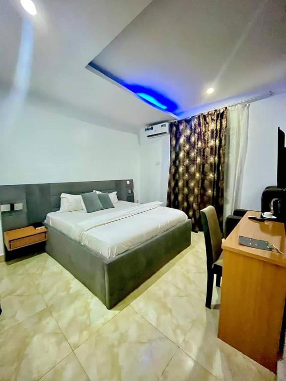 a bedroom with a bed and a desk with a computer at Padelia Hotels Ltd in Nsukka