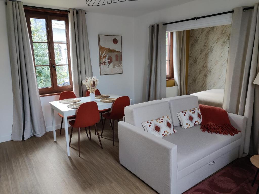 a living room with a white couch and a table at Studio Cosy in Feuquières