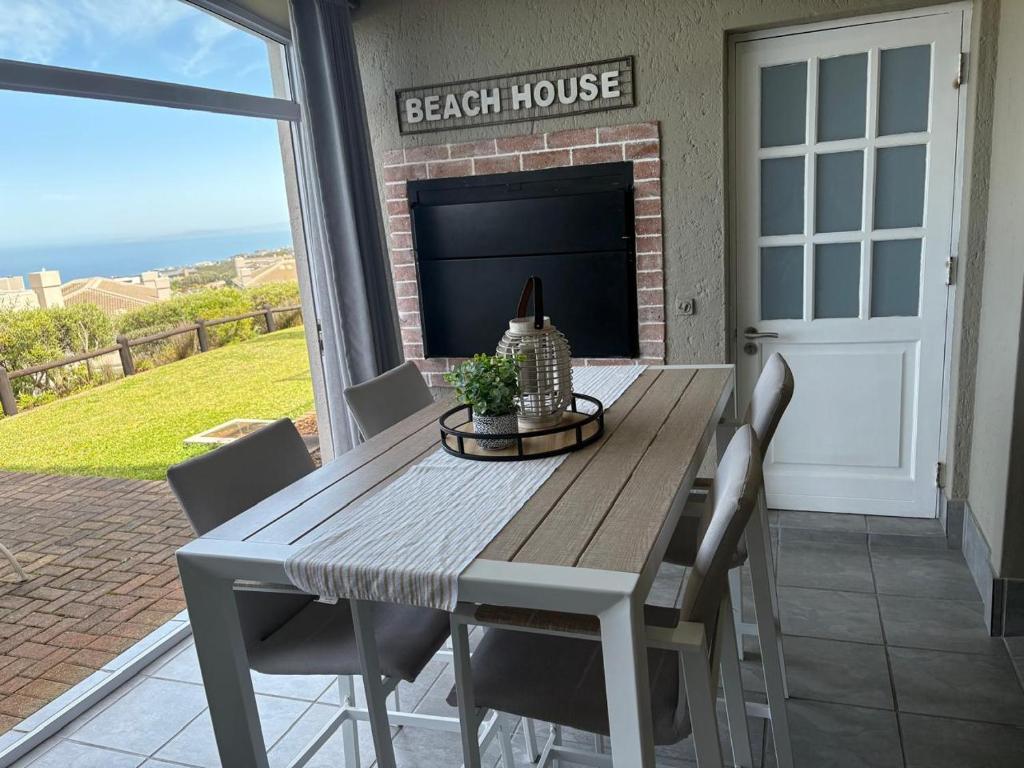 a table and chairs on a porch with a fireplace at Pinnacle Golf Villa 24-3 in DʼAlmeida