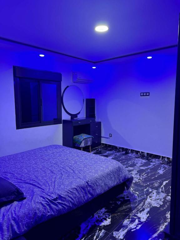 a bedroom with a bed and a mirror on the wall at Villa piscine GDYEL in Arzew