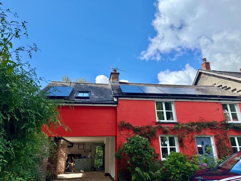 a red house with a red garage at Stunning views of Ynyshir & Southern Snowdonia in Machynlleth