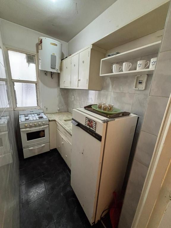 a small kitchen with a stove and a refrigerator at Departamento a 2 cuadras de la playa in Mar del Plata
