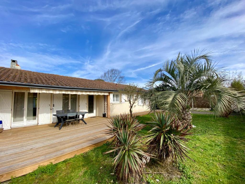 a house with a wooden deck with a piano at Maison paisible in Gujan-Mestras