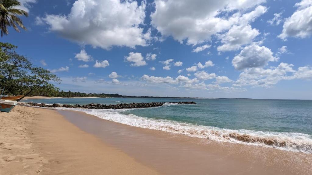 a sandy beach with a view of the ocean at Amurasan beach studio in Tangalle
