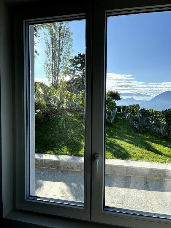 a window with a view of a yard at Renovated APT with panoramic view in Cully