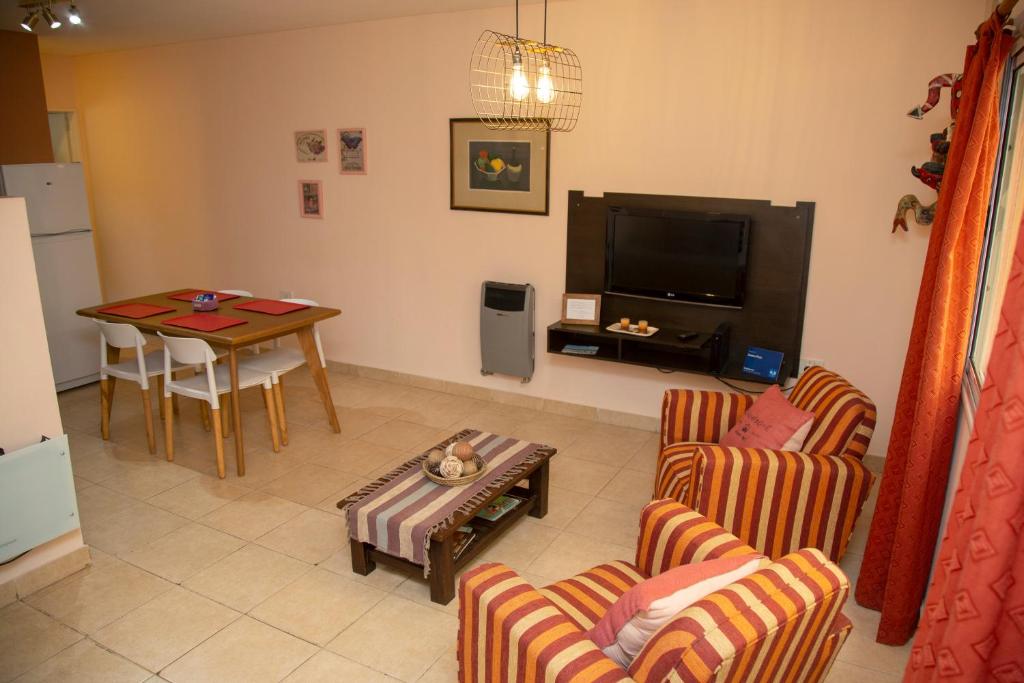 a living room with chairs and a table and a television at Centro Peru in Paraná