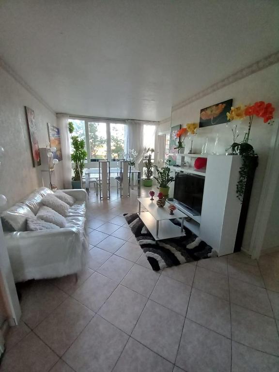 a living room with a couch and a table at Chambres chez l'habitant in Meudon