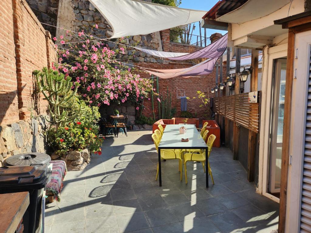 a patio with a table and chairs and flowers at La Casa Piola in Valparaíso