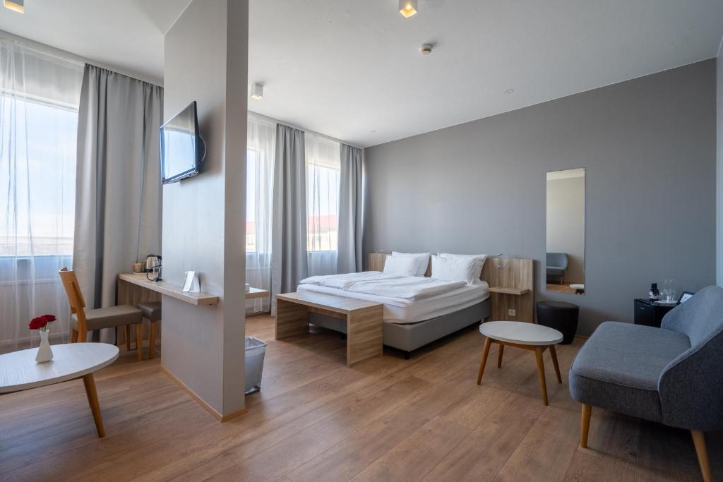 a bedroom with a bed and a living room with a couch at Hótel Laugarbakki in Laugarbakki