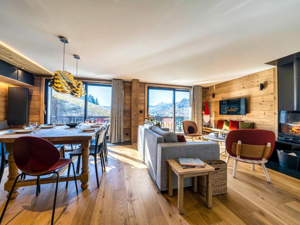 a living room with a table and a couch at Appartement de Charme 4* au Centre des Gets - Accès Direct aux Pistes de Ski - FR-1-598-28 in Les Gets