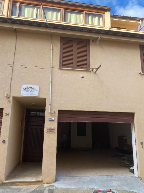 a building with two garage doors and a sign on it at Casa Madonie Isnello in Isnello