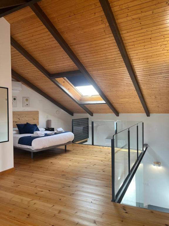 Un dormitorio con una cama y un techo de madera. en MINAS CENTRO, en Úbeda