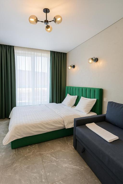 a bedroom with a large bed and a couch at Стрийська Автовокзал Арена Львів in Lviv