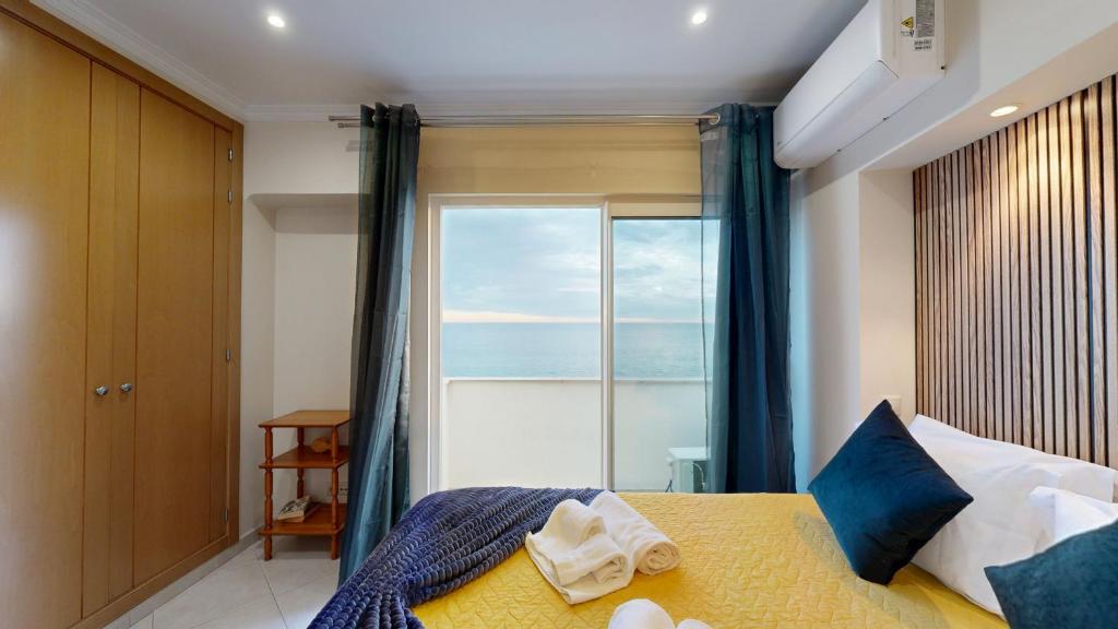 a bedroom with a bed with a view of the ocean at Apartamento T1 Pau da Bandeira in Caliços