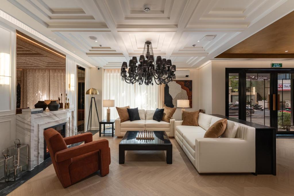 sala de estar con sofá, sillas y lámpara de araña en The Savile, by Harry's, en Hanói