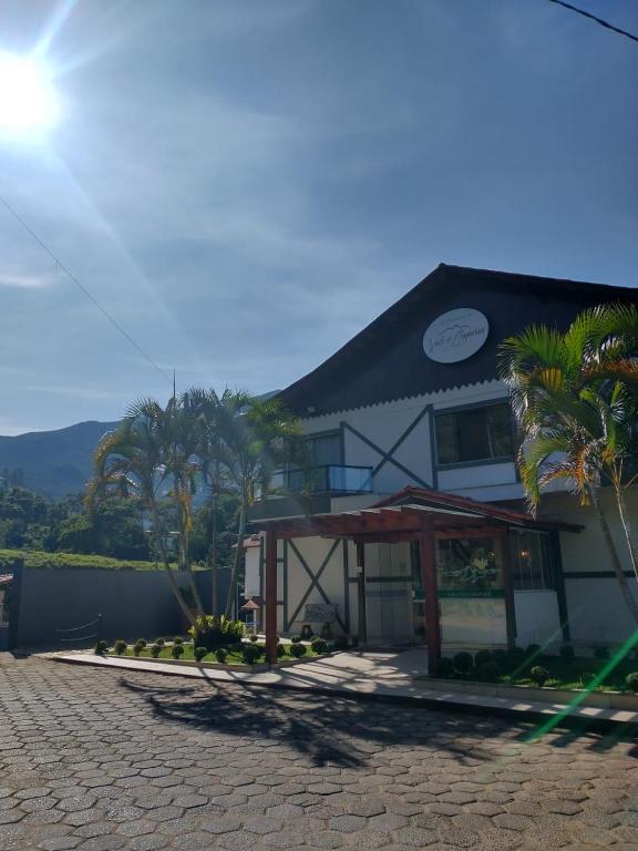 a building with palm trees in front of it at Pousada Vale do Caparaó in Caparaó Velho