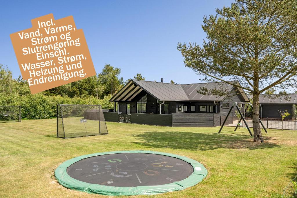 a sign in front of a house with a trampoline at Hedevang 22 Houstrup in Nørre Nebel