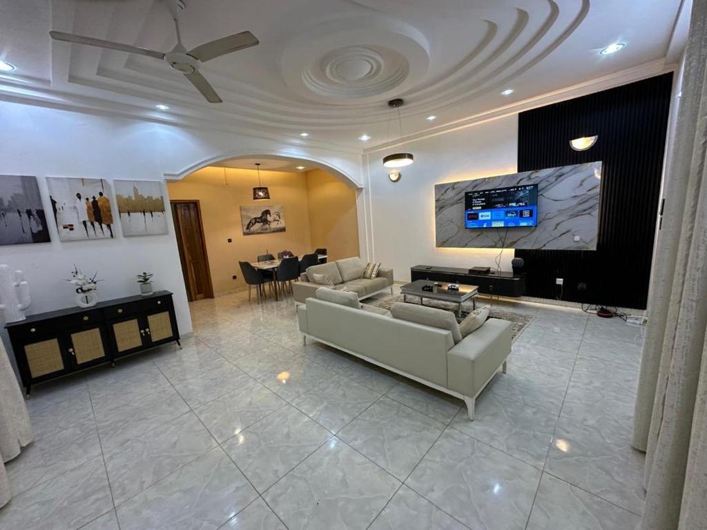 a living room with couches and a flat screen tv at Résidence Bonheur in Ouagadougou