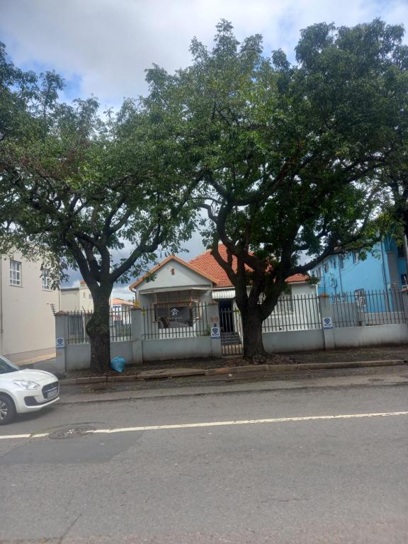 a house with a white fence and two trees at JH Guest house in Durban