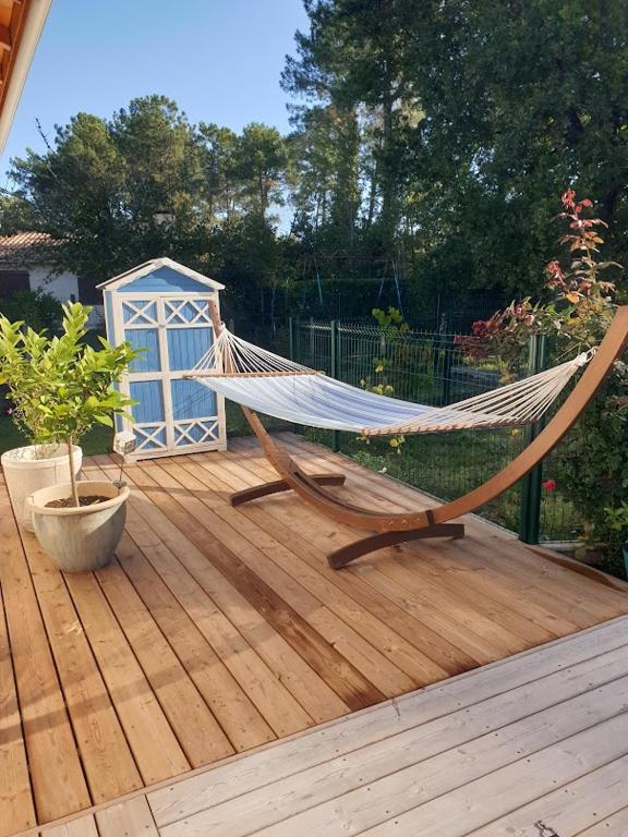 a hammock on top of a wooden deck at Villa Kentève in Parentis-en-Born